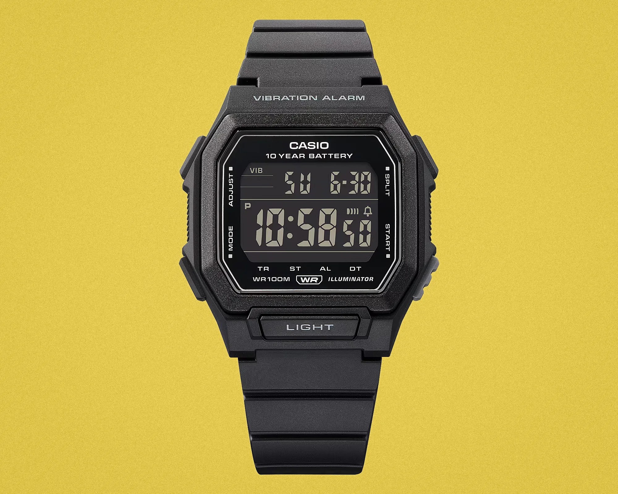 Black Casio digital wristwatch with vibration alarm and 10-year battery on yellow background.