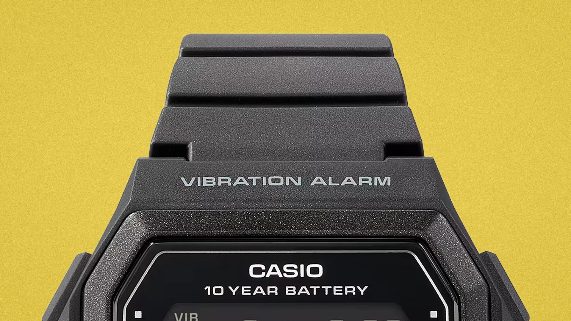 Close-up of a black Casio digital watch with "Vibration Alarm" and "10 Year Battery" text on the face.