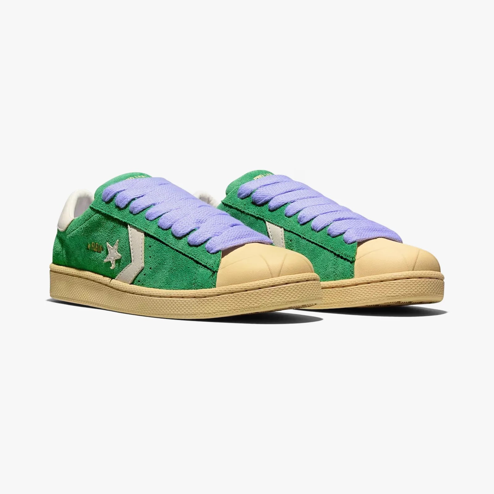 Green suede sneakers with beige rubber toe caps, beige soles, white side chevron and star logo, and lavender laces.