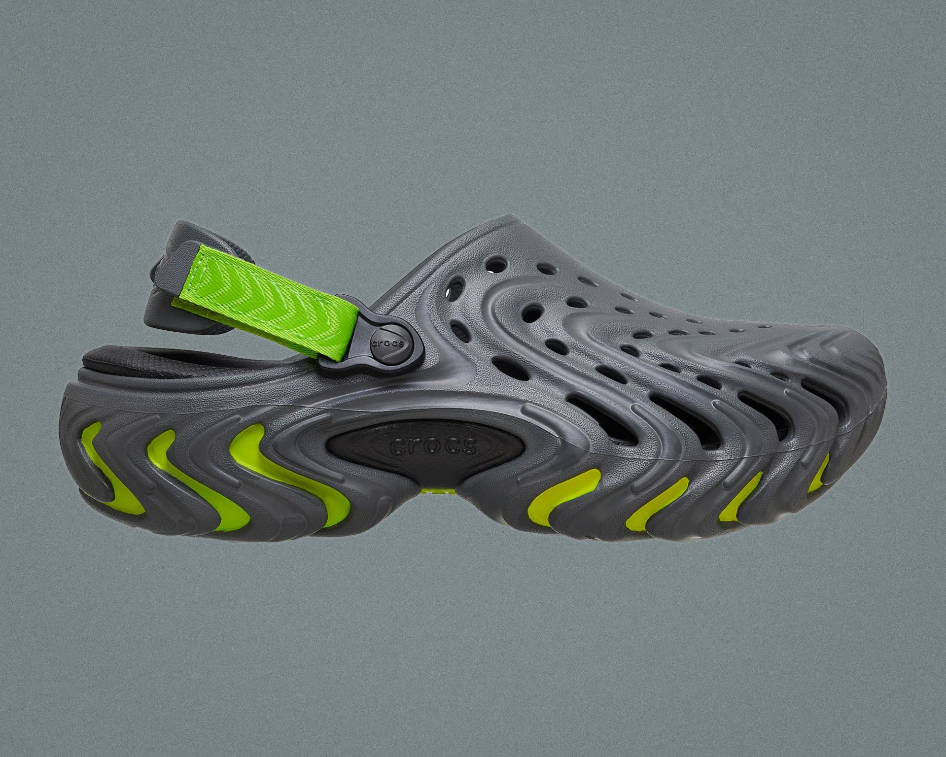Gray Crocs clog with neon green strap and sole accents on a gray background.