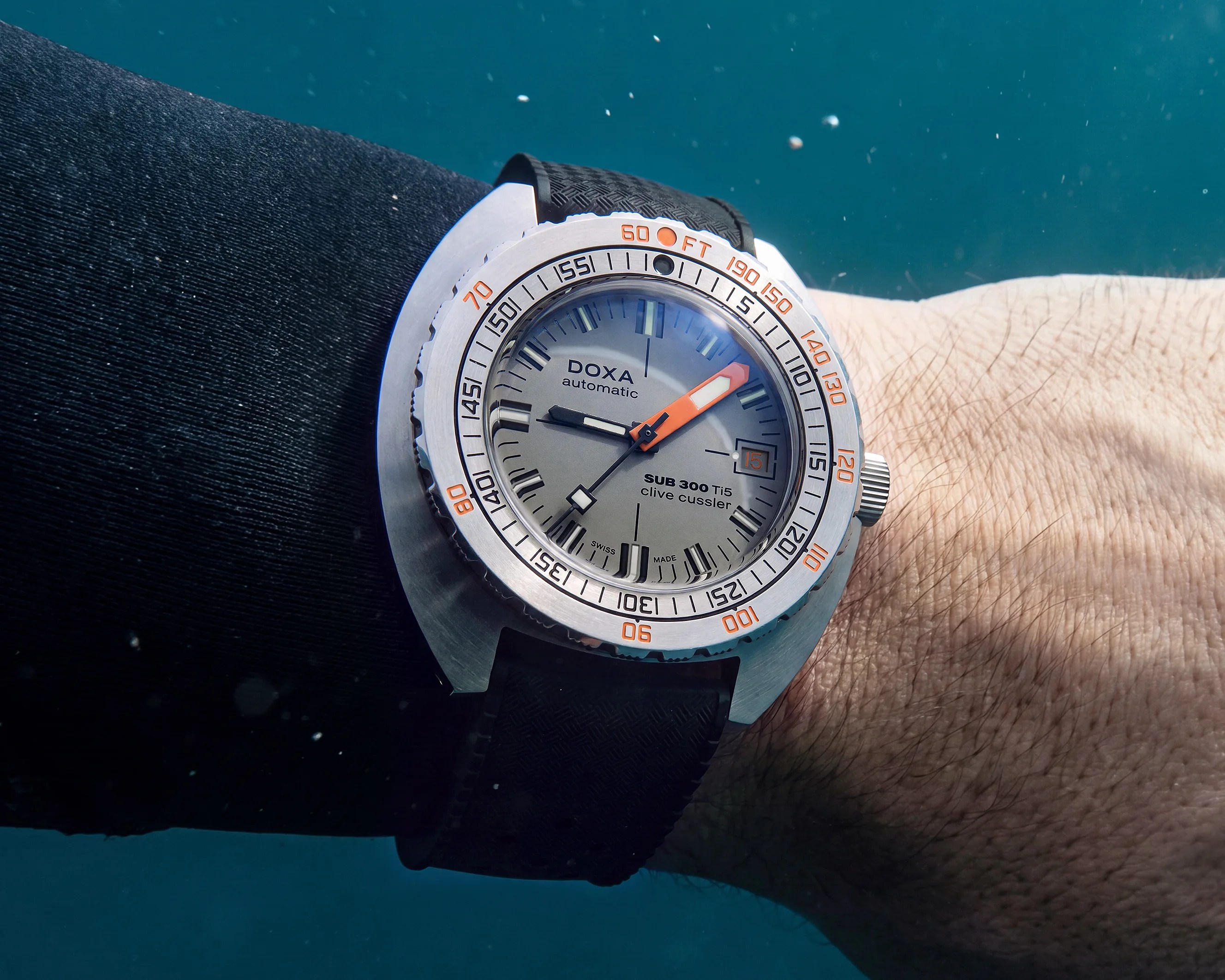 Silver DOXA SUB 300 Ti5 automatic dive watch with black rubber strap underwater on a wrist.