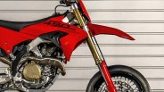 Close-up of red Ducati 450 Desmo SM motorcycle front and engine with gold suspension forks and black tire.