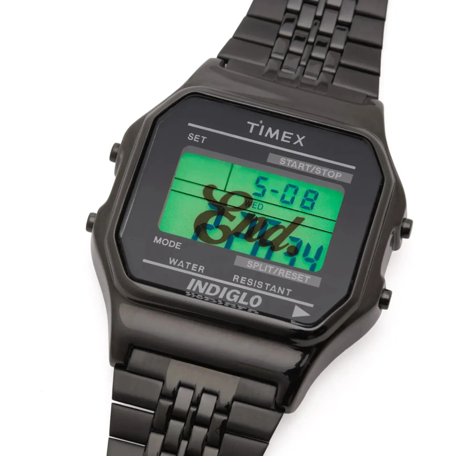 Black Timex digital watch with metal link band and green backlit display showing date and time.