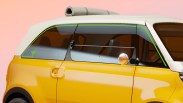 Yellow compact car with white roof and rolled-up mat on top, showing side windows and door.