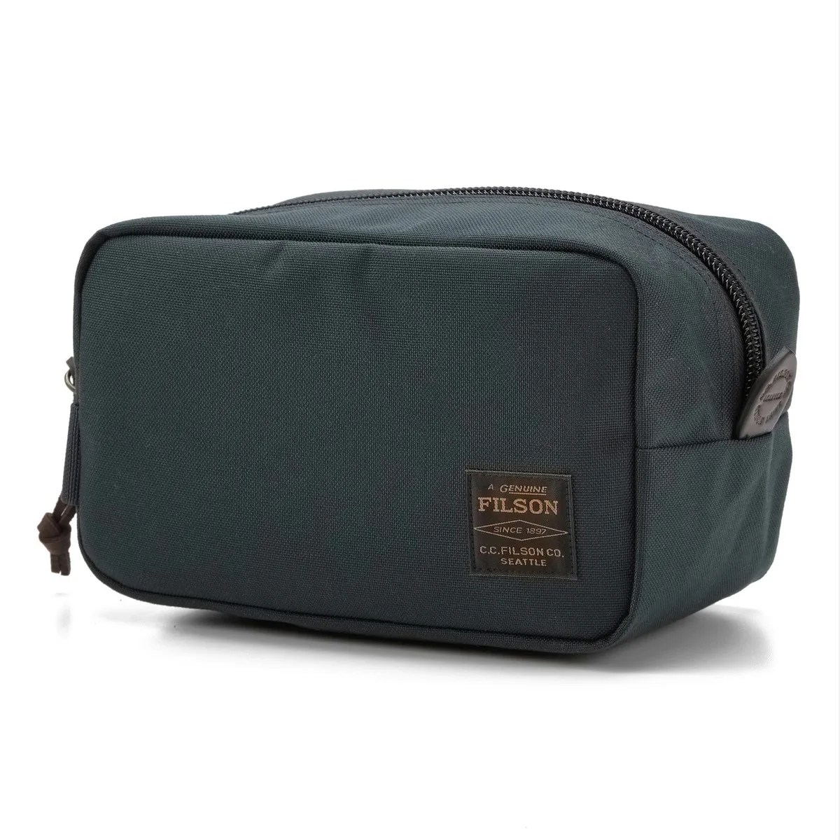 Dark green rectangular canvas toiletry bag with a front label reading "Filson" and a top zipper.