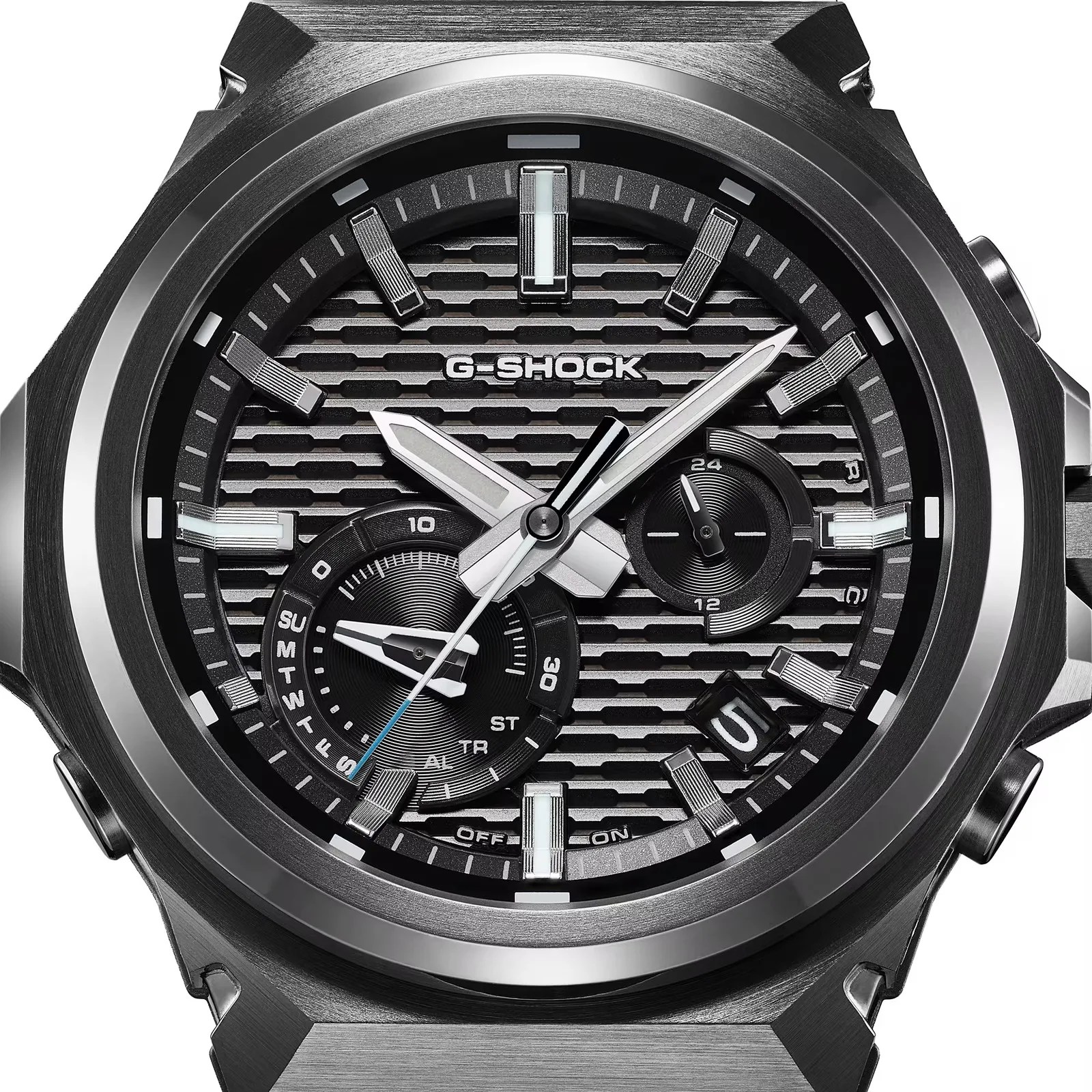 Close-up of a black and silver G-Shock watch face with textured dial, luminous hands, subdials, and date display.