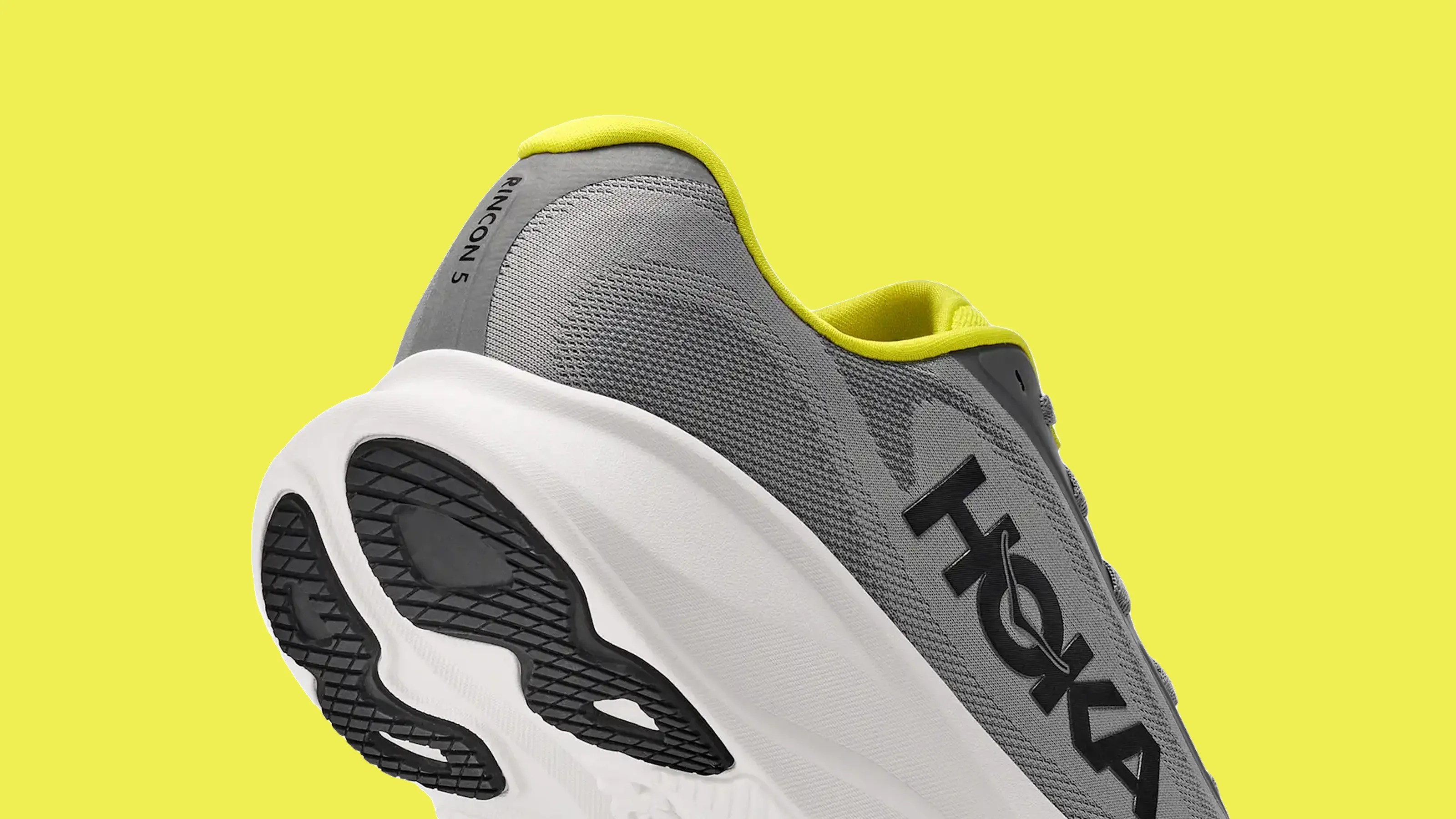 Gray and yellow Hoka Rincon 5 running shoe with white sole on a yellow background.