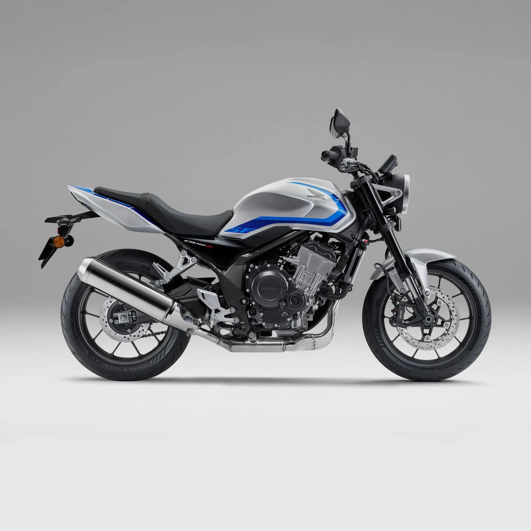 Silver and blue Honda motorcycle with black seat and exhaust pipe on gray background.