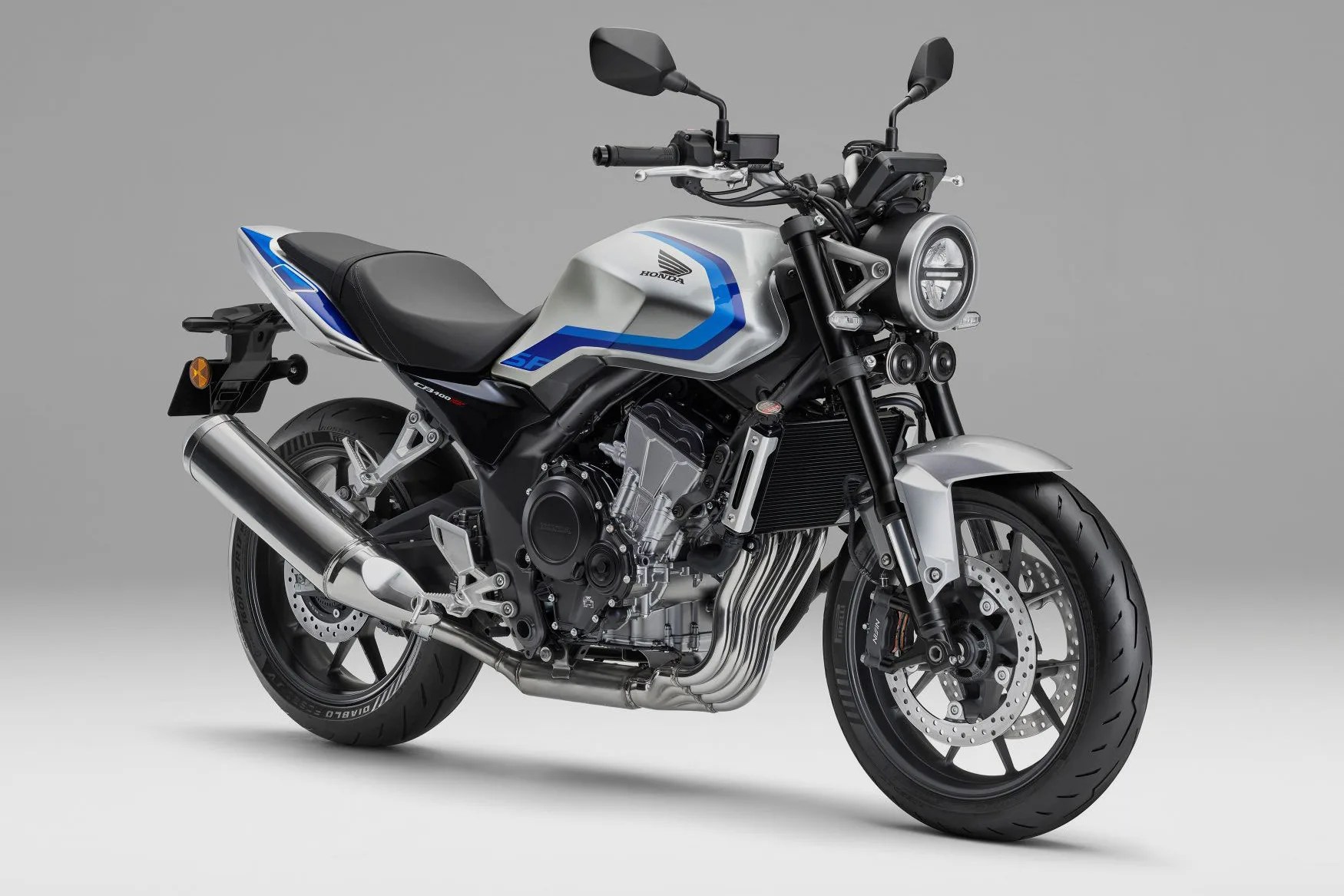 Silver and blue Honda CB1000R motorcycle with black seat and dual round headlights on gray background.