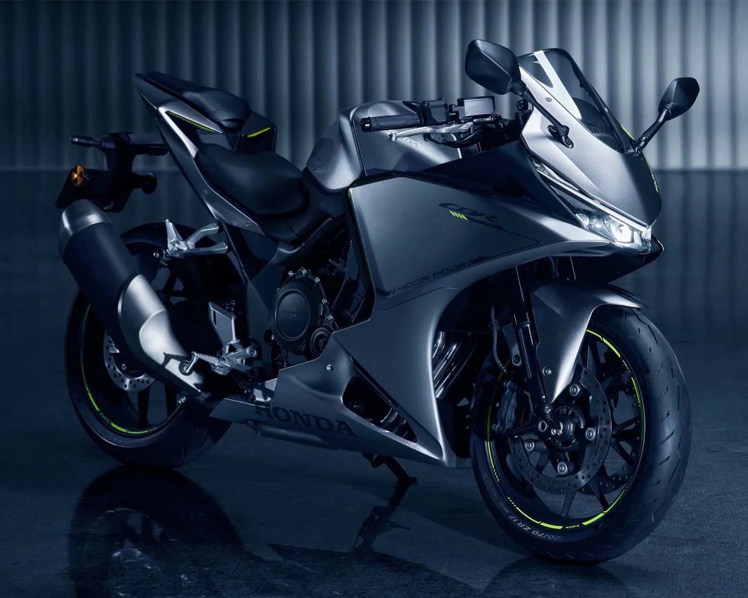 Matte gray Honda sport motorcycle with black seat and neon yellow accents on tires and body.