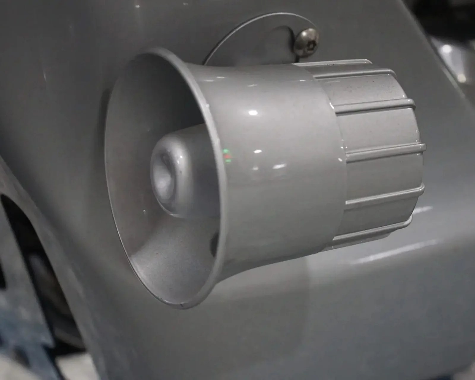 Close-up of a gray plastic knob with ridges mounted on a gray surface.