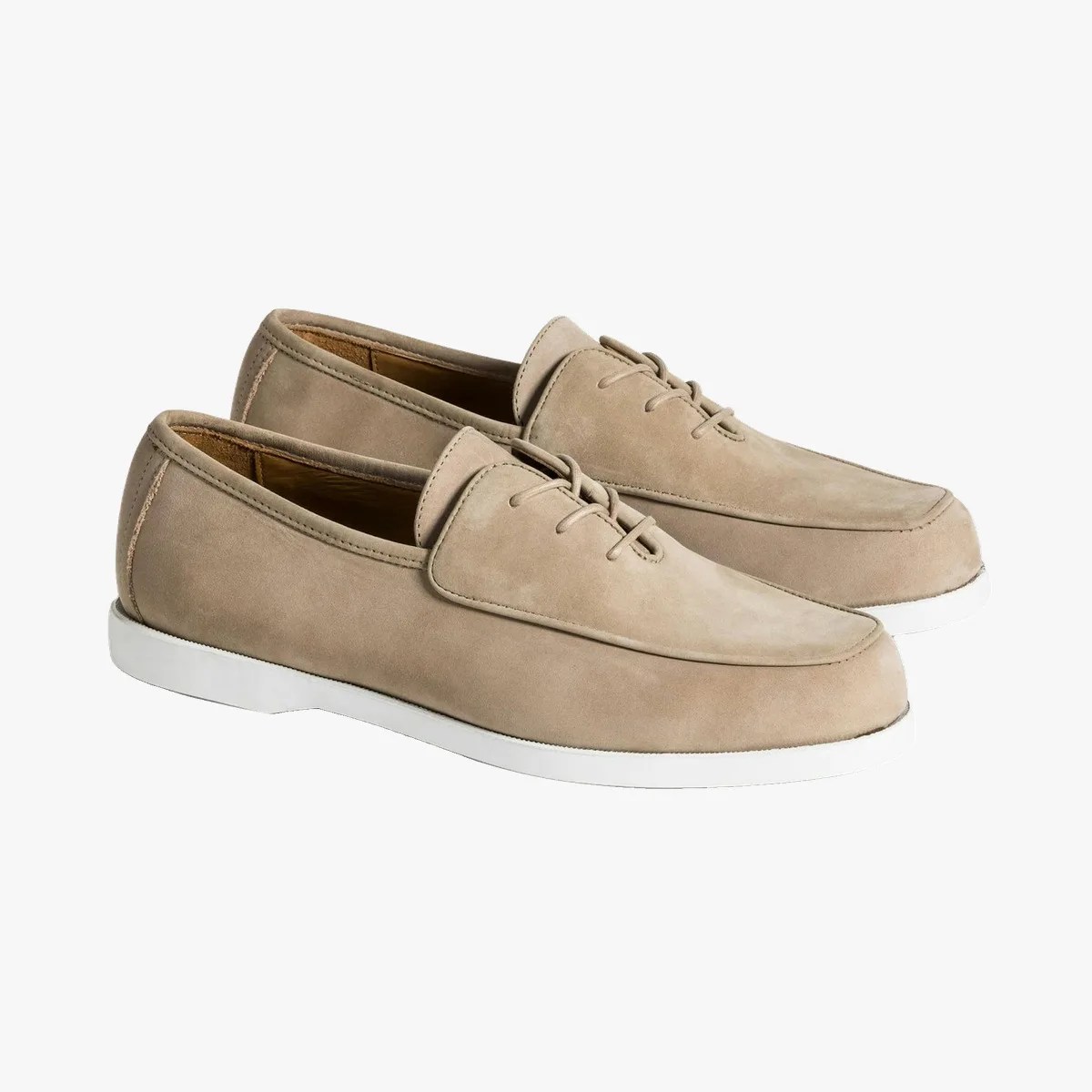 Pair of beige suede lace-up loafers with white rubber soles on a white background.