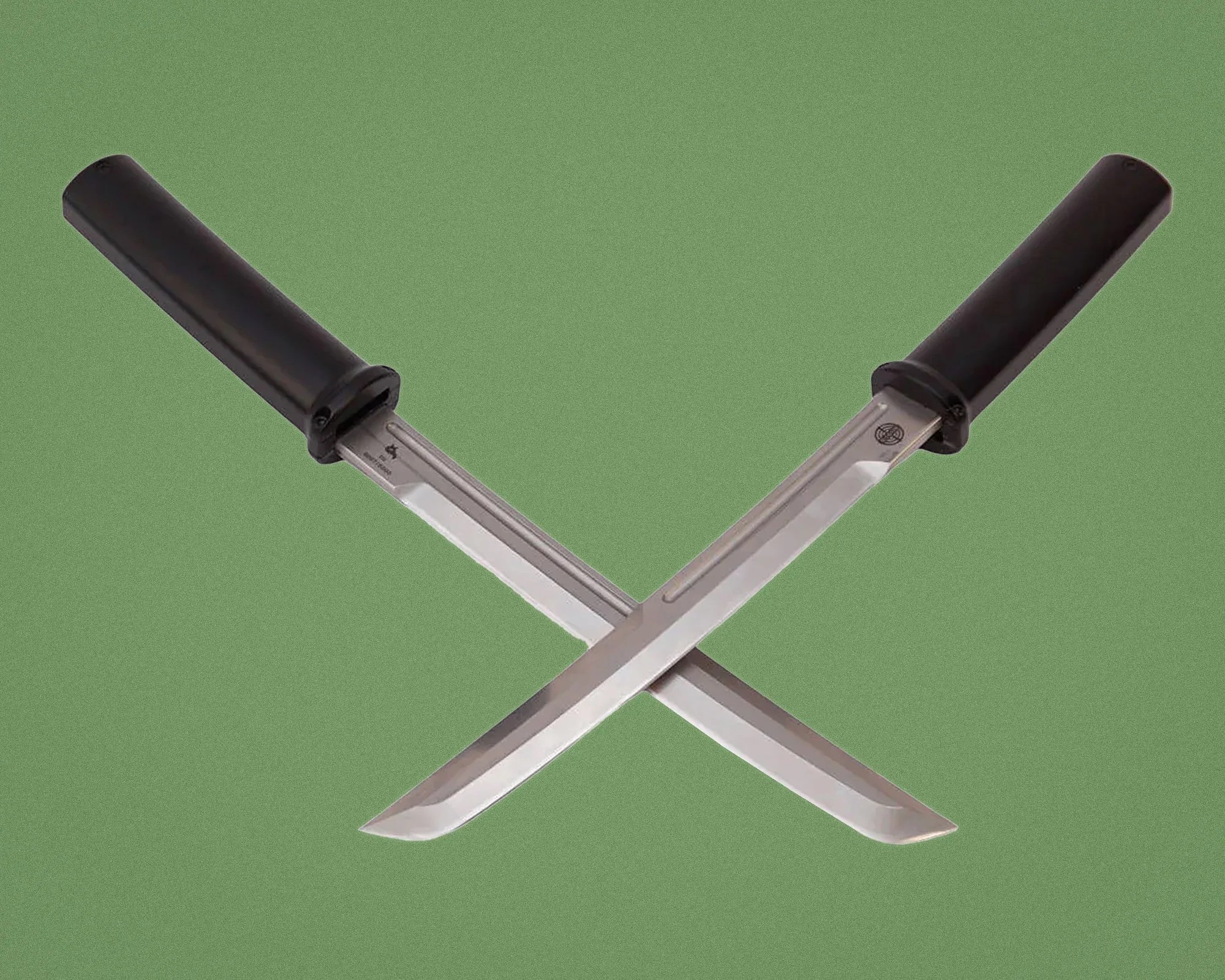 Pair of crossed stainless steel knives with black cylindrical handles on a green background.