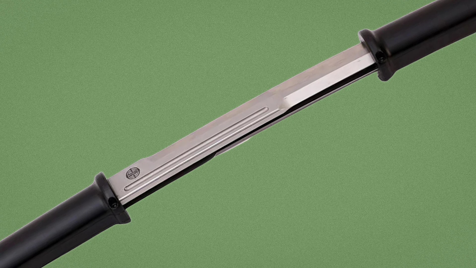 Close-up of a stainless steel blade with black plastic handles on both ends against a green background.