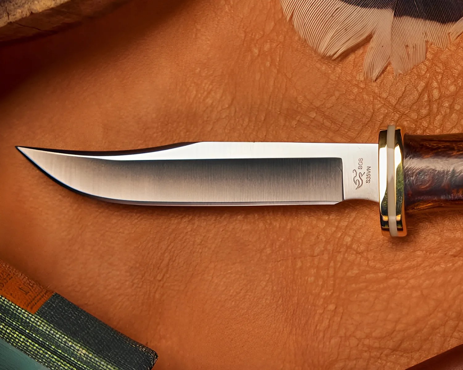 Fixed-blade knife with a polished steel blade, wooden handle, and brass guard on a leather surface.