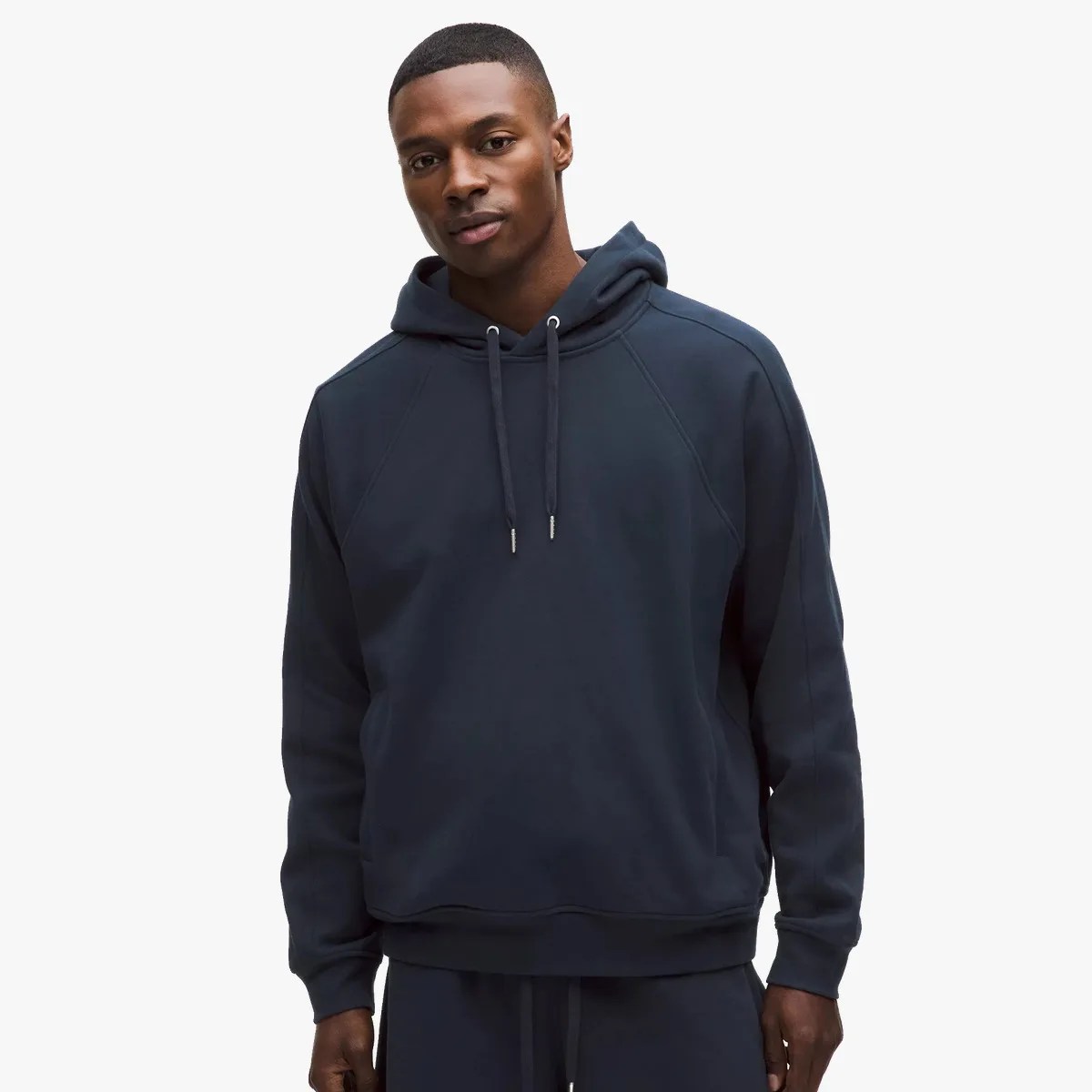 Navy blue pullover hoodie with drawstrings worn by a person against a white background.