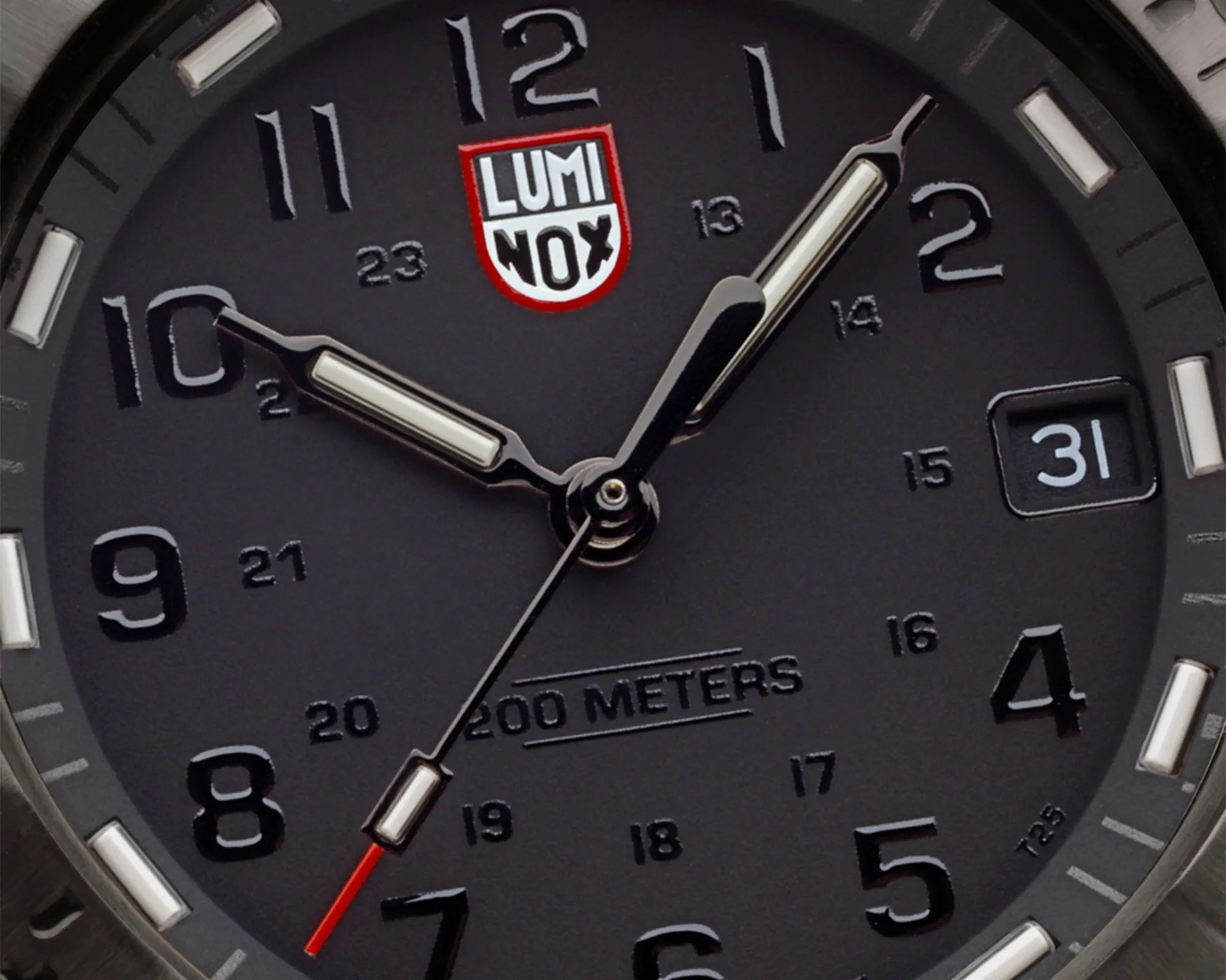 Close-up of a black Luminox watch face showing hour, minute, and second hands with date window at 3 o'clock.
