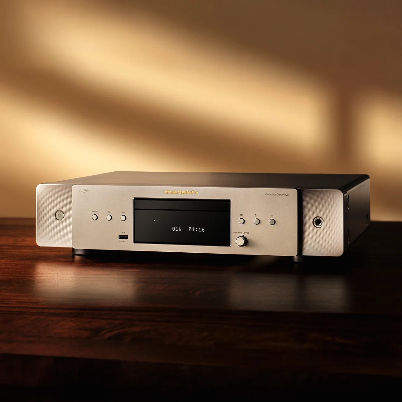 Marantz CD70 silver and black compact disc player on a wooden surface with warm lighting.