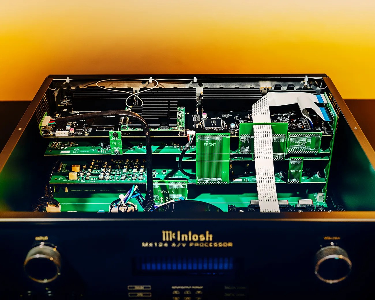 Open McIntosh MX124 A/V processor showing internal green circuit boards and ribbon cables.