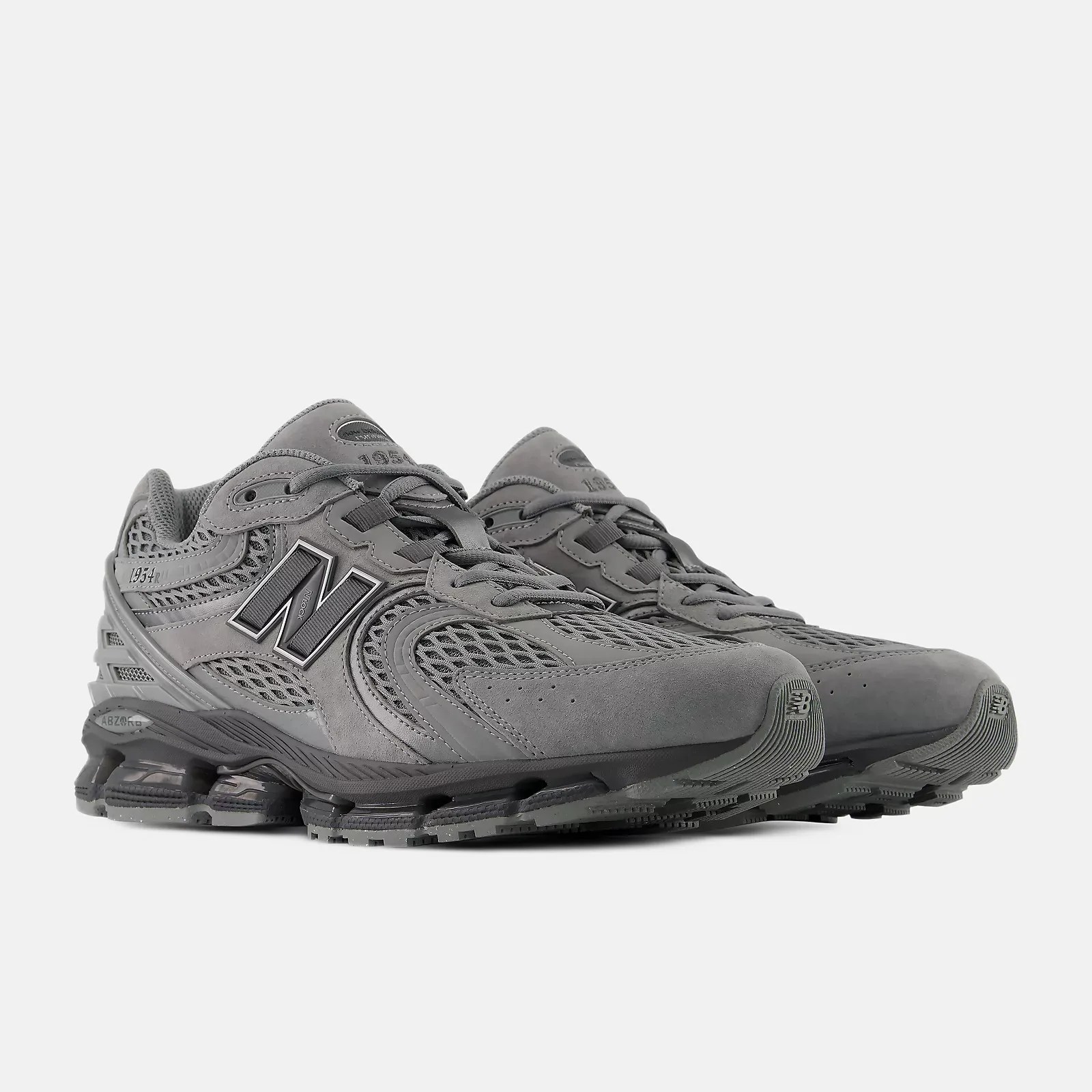 Pair of gray New Balance 1954R sneakers with mesh and suede upper and cushioned sole.
