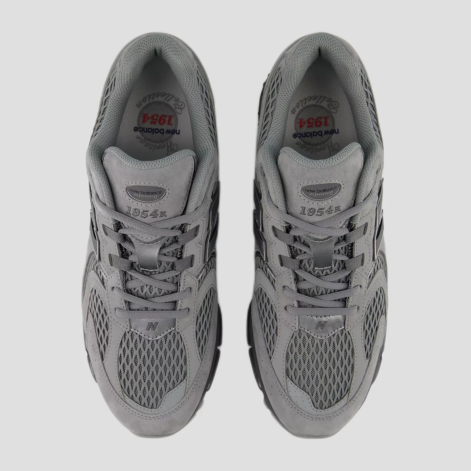 Pair of gray New Balance 1954r sneakers with mesh and suede uppers viewed from above.