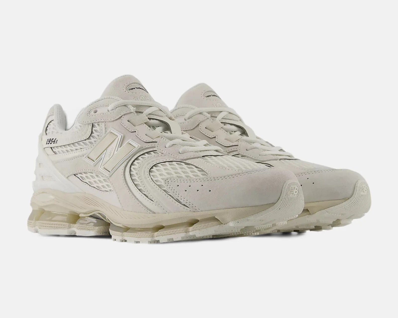 Pair of off-white New Balance 1954R sneakers with mesh and suede upper and cushioned sole.