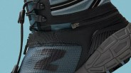 Close-up of a blue and black sneaker with black laces and a textured gray sole.