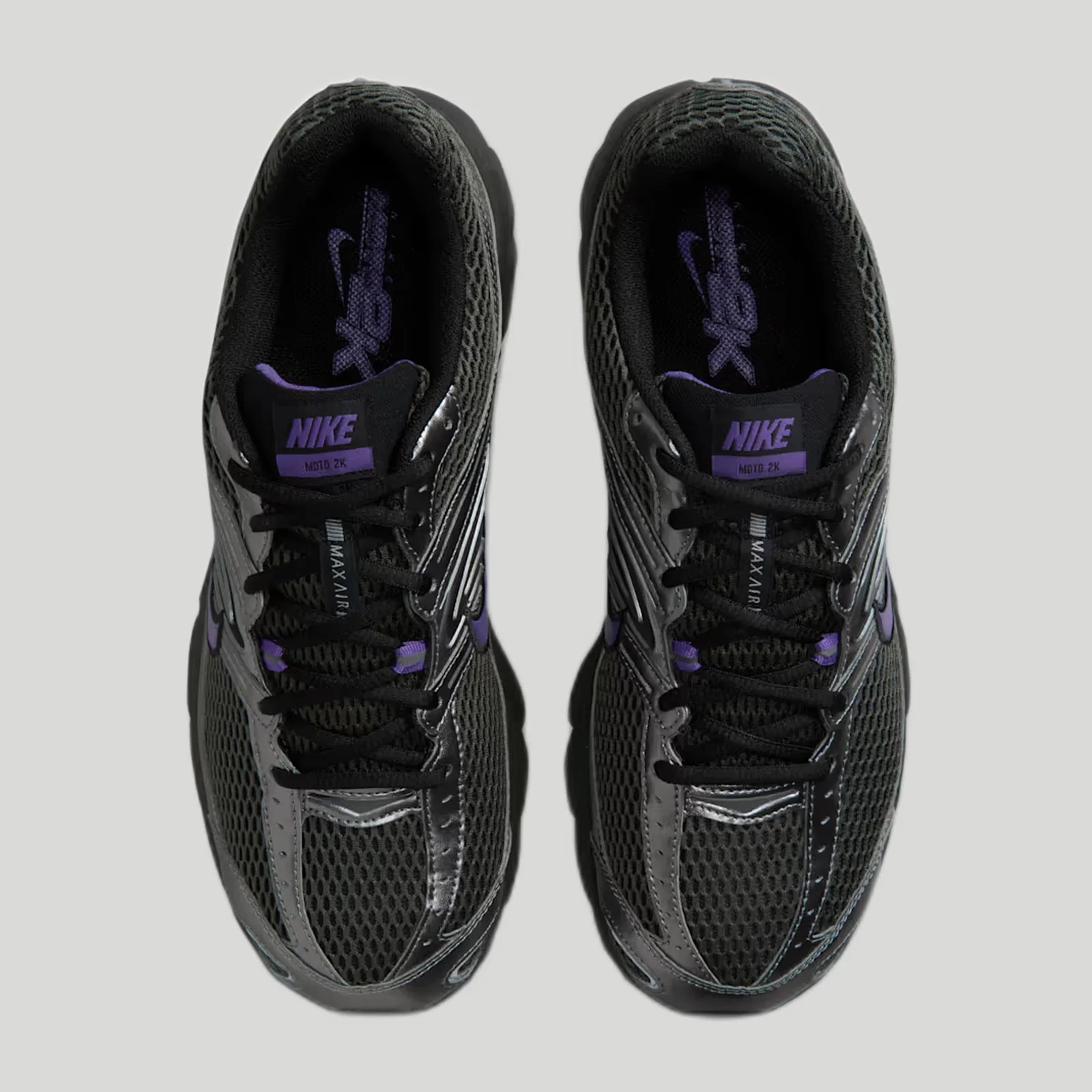 Pair of black Nike MD10 2K sneakers with purple accents viewed from above on a gray background.