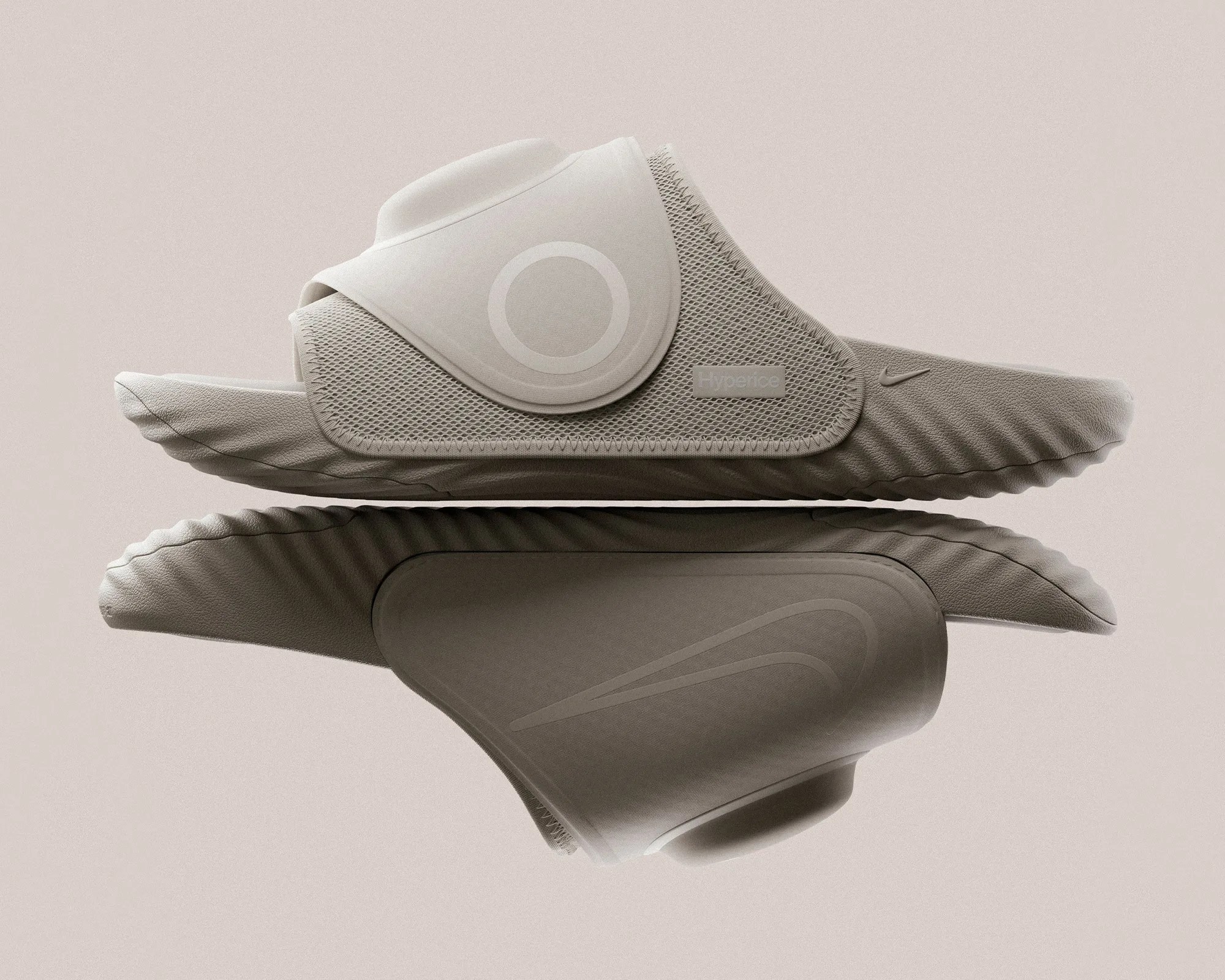 Beige slip-on sandal with textured sole, mesh side panel, and adjustable strap with circular detail.