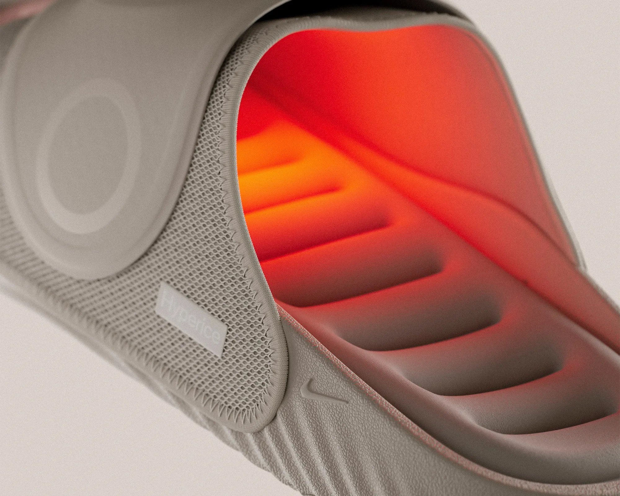 Close-up of a gray cushioned shoe sole with a glowing red-orange interior and textured fabric exterior.