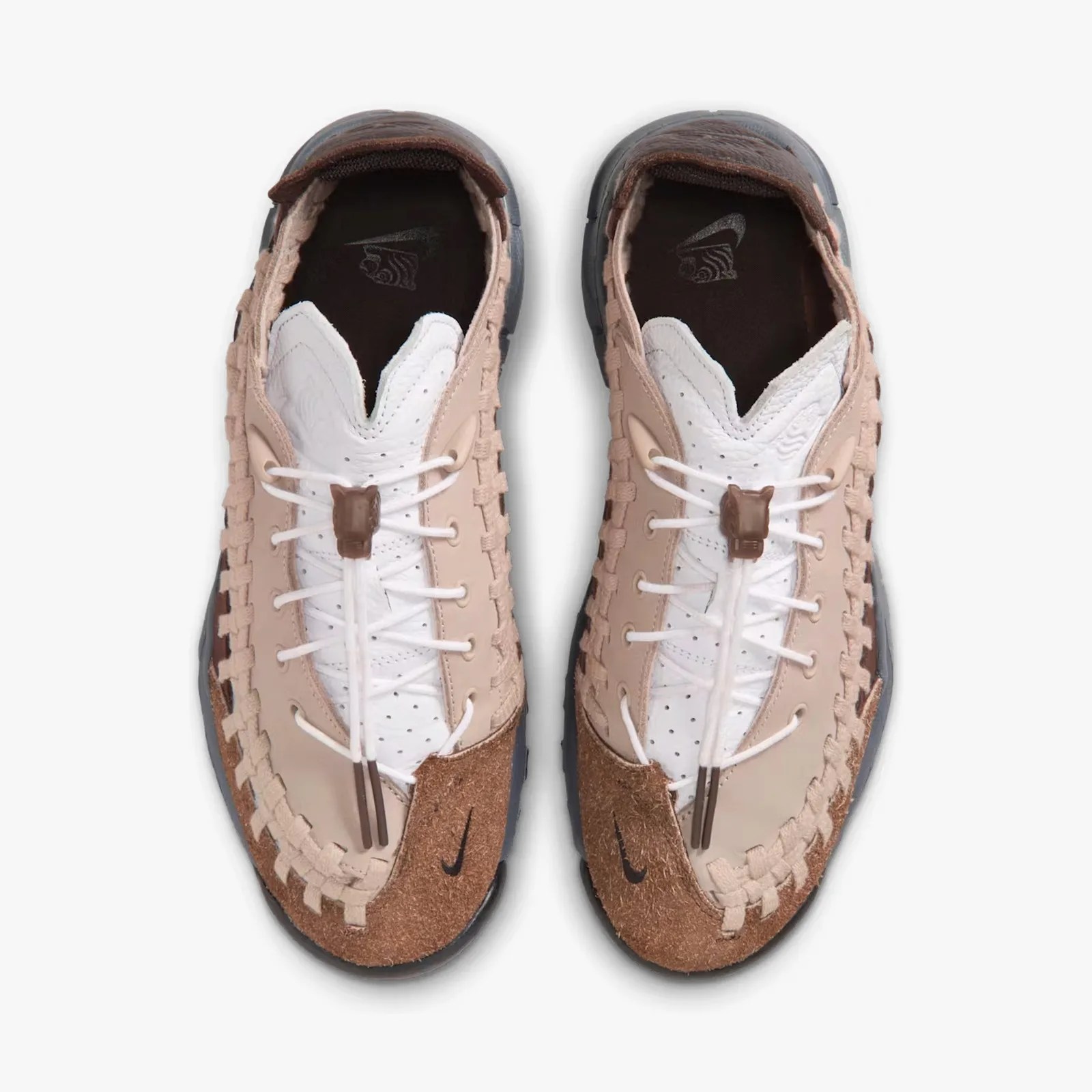 Pair of beige and white Nike sneakers with woven detailing and brown suede accents, viewed from above.