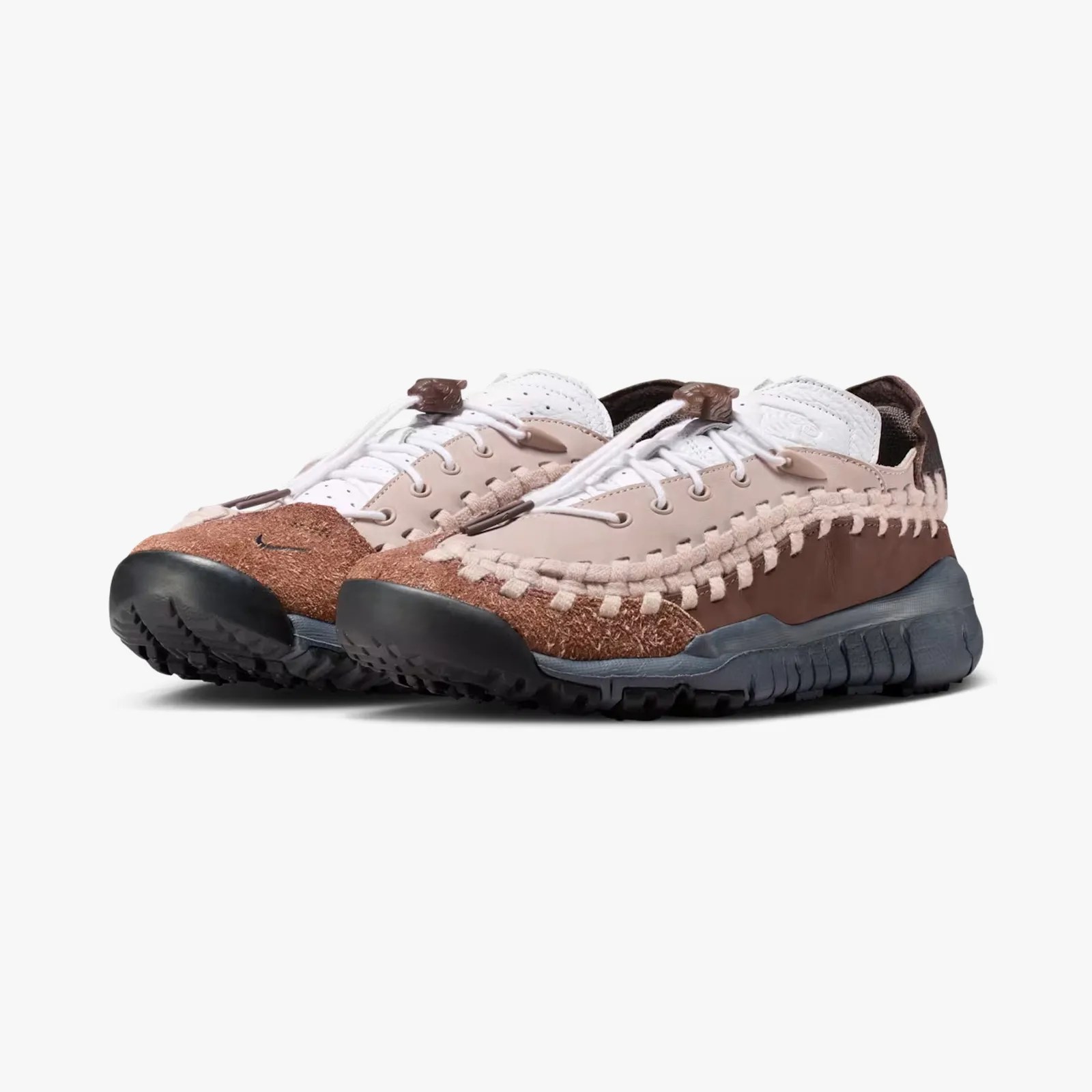 Brown and beige Nike sneakers with woven detailing and black soles on a white background.