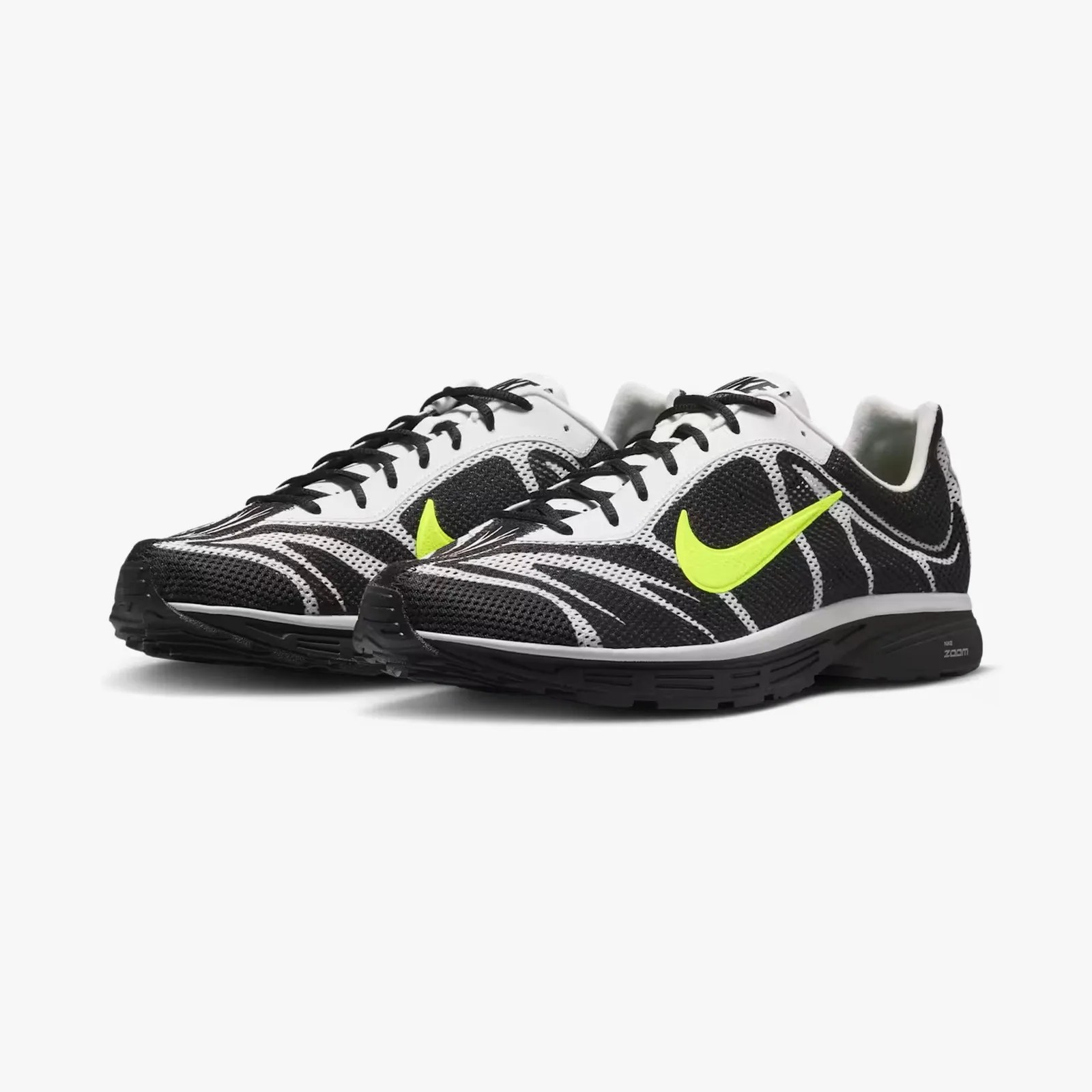 Pair of black and white Nike running shoes with neon yellow swoosh logos and black laces.