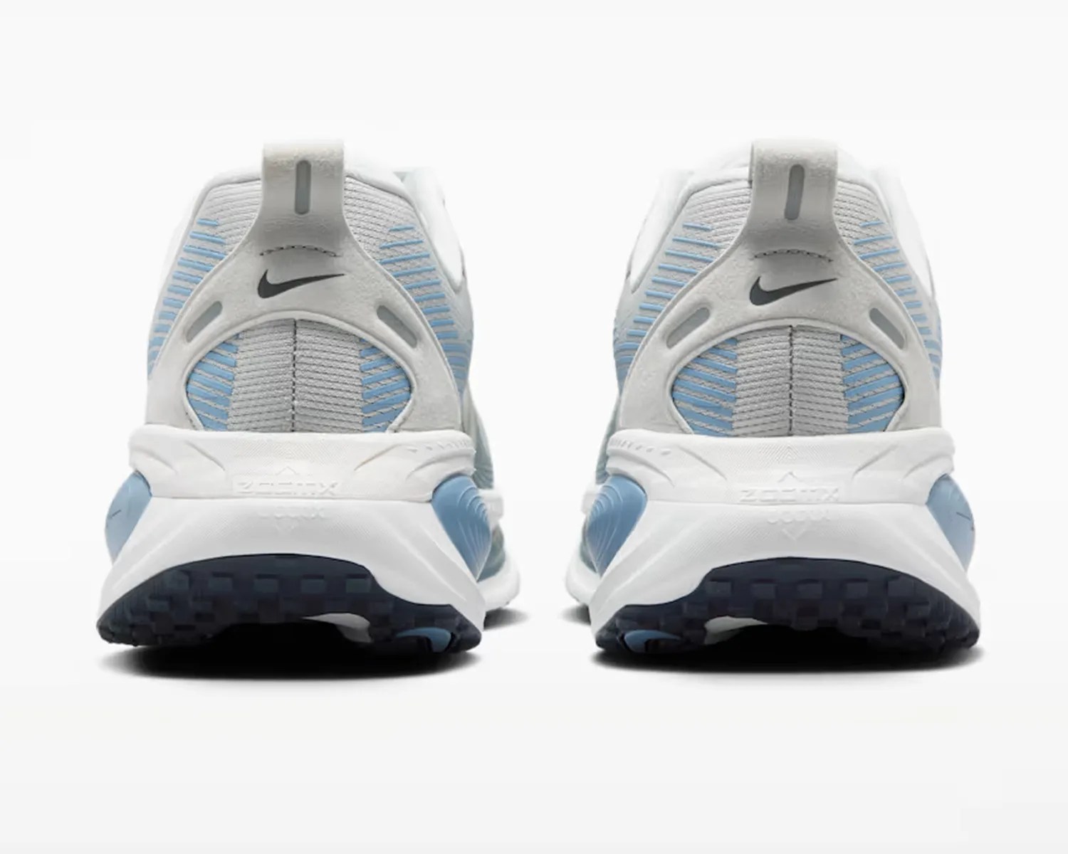 Pair of white and light blue Nike running shoes viewed from the back showing the heel and sole.
