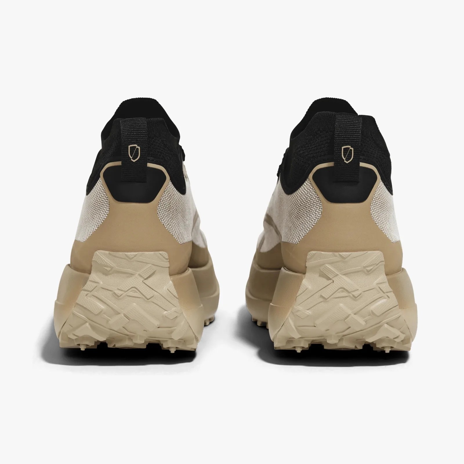 Pair of beige and black athletic shoes shown from the back with textured beige soles and black heel tabs.