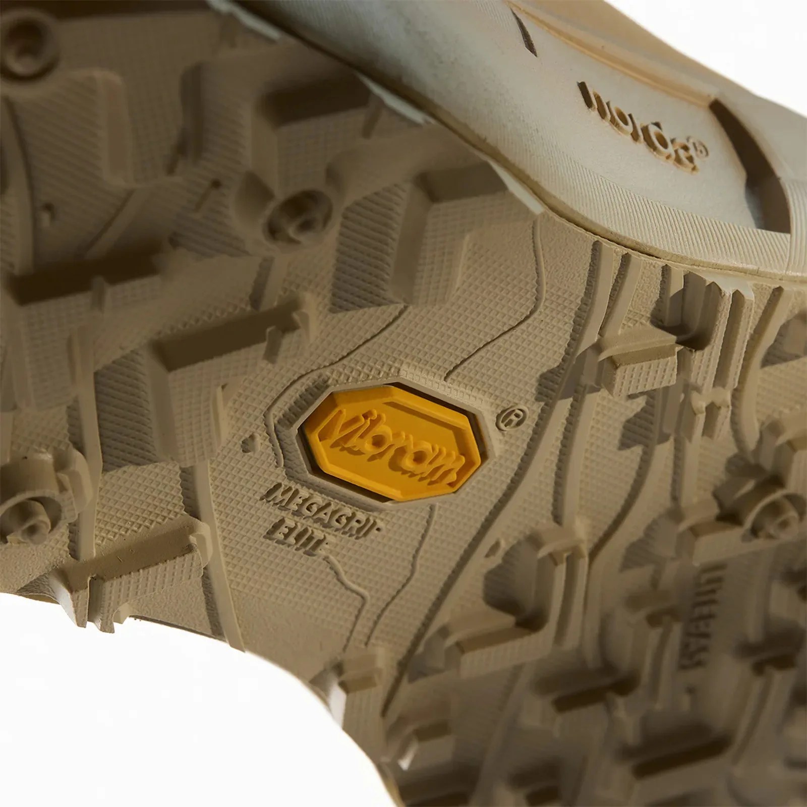 Close-up of a beige Vibram Megagrip Elite shoe sole with textured tread and yellow Vibram logo.