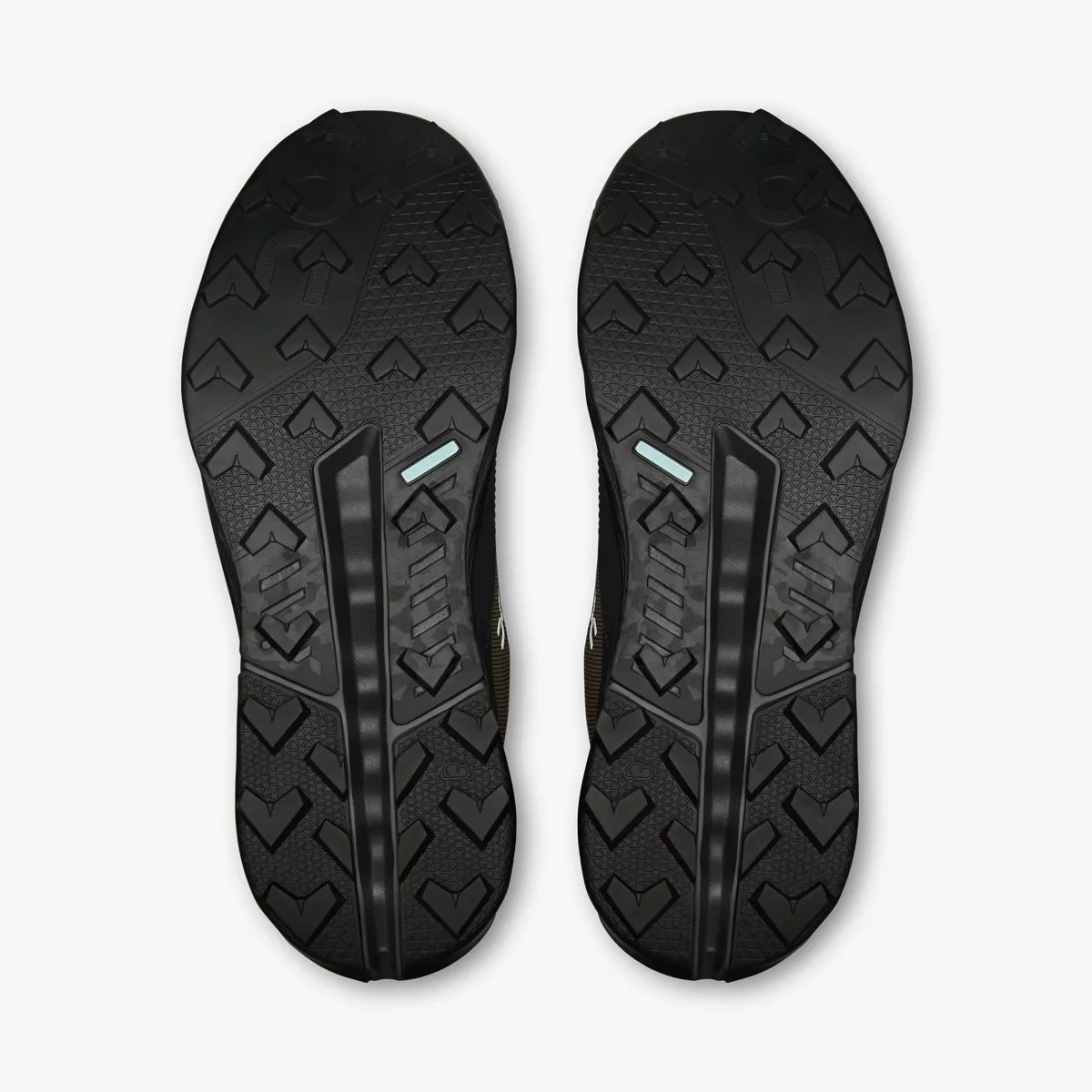 Pair of black shoe soles with textured, arrow-shaped treads and a central groove.