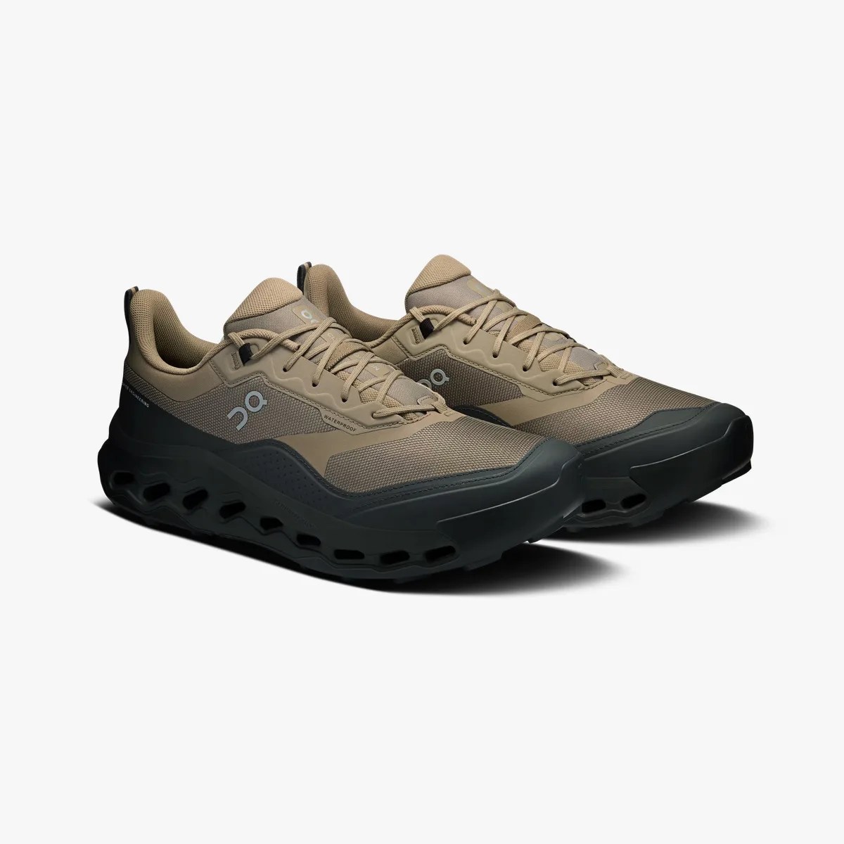 Pair of tan and black waterproof athletic shoes with thick, ventilated black soles on a white background.