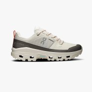 Beige and dark gray waterproof trail running shoe with rugged sole and red pull tab.
