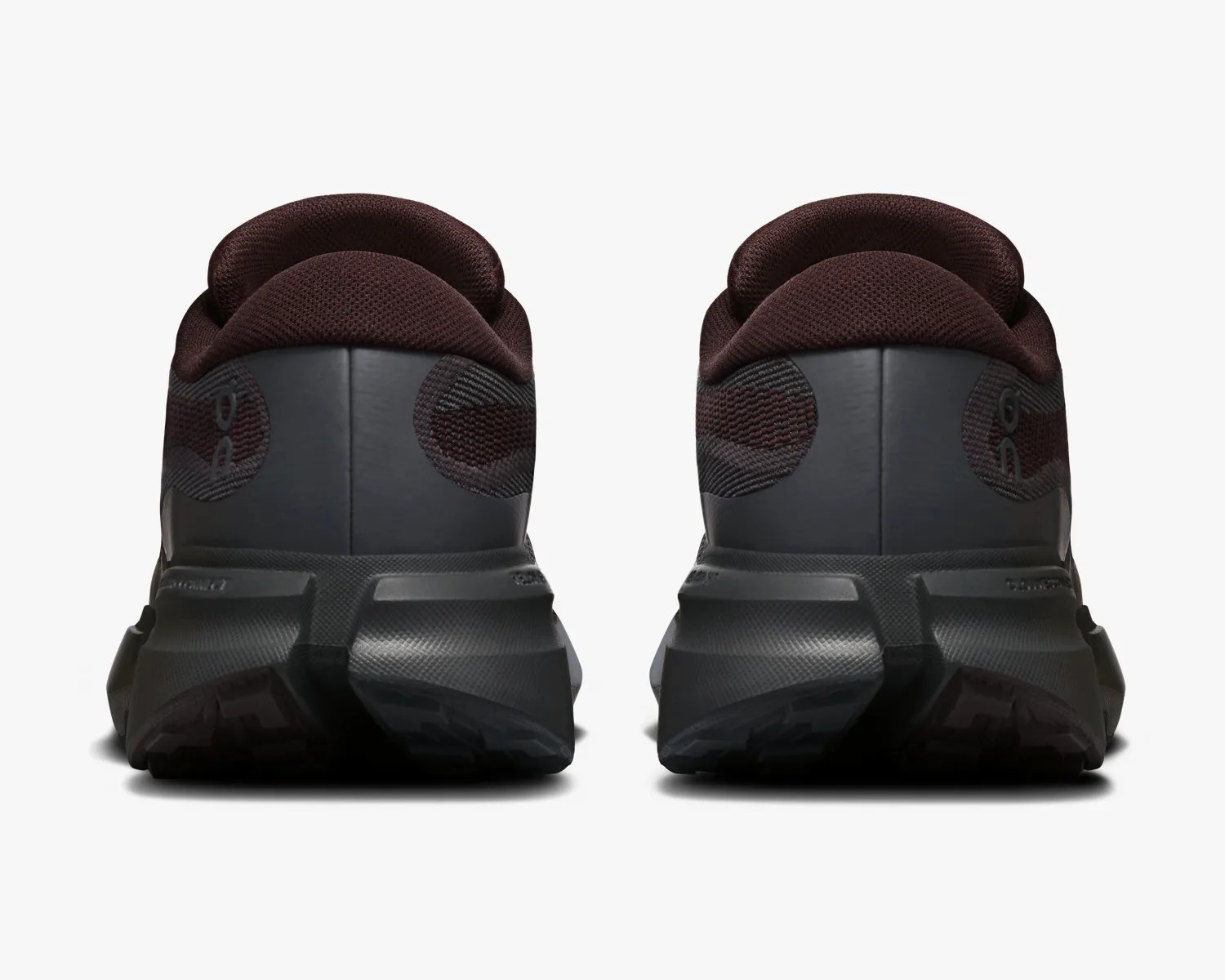 Pair of dark brown and black athletic shoes shown from the back on a white background.