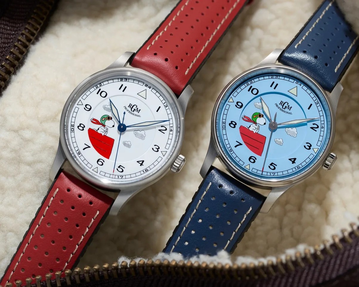 Two wristwatches with Snoopy pilot illustrations, one with a white dial and red perforated leather strap, the other with a blue dial and blue perforated leather strap.