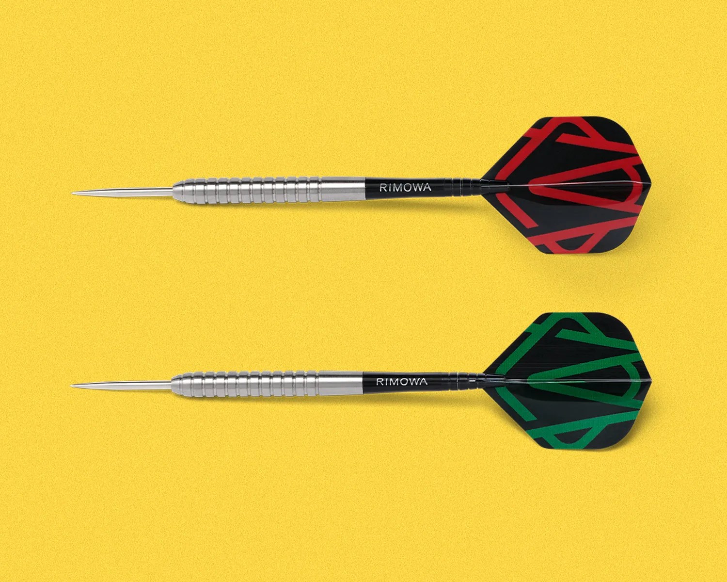 Two metal darts with black shafts and flights, one with red and one with green geometric patterns, on a yellow background.