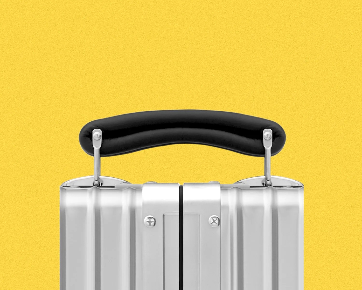 Black padded handle attached to a silver hard-shell suitcase against a yellow background.