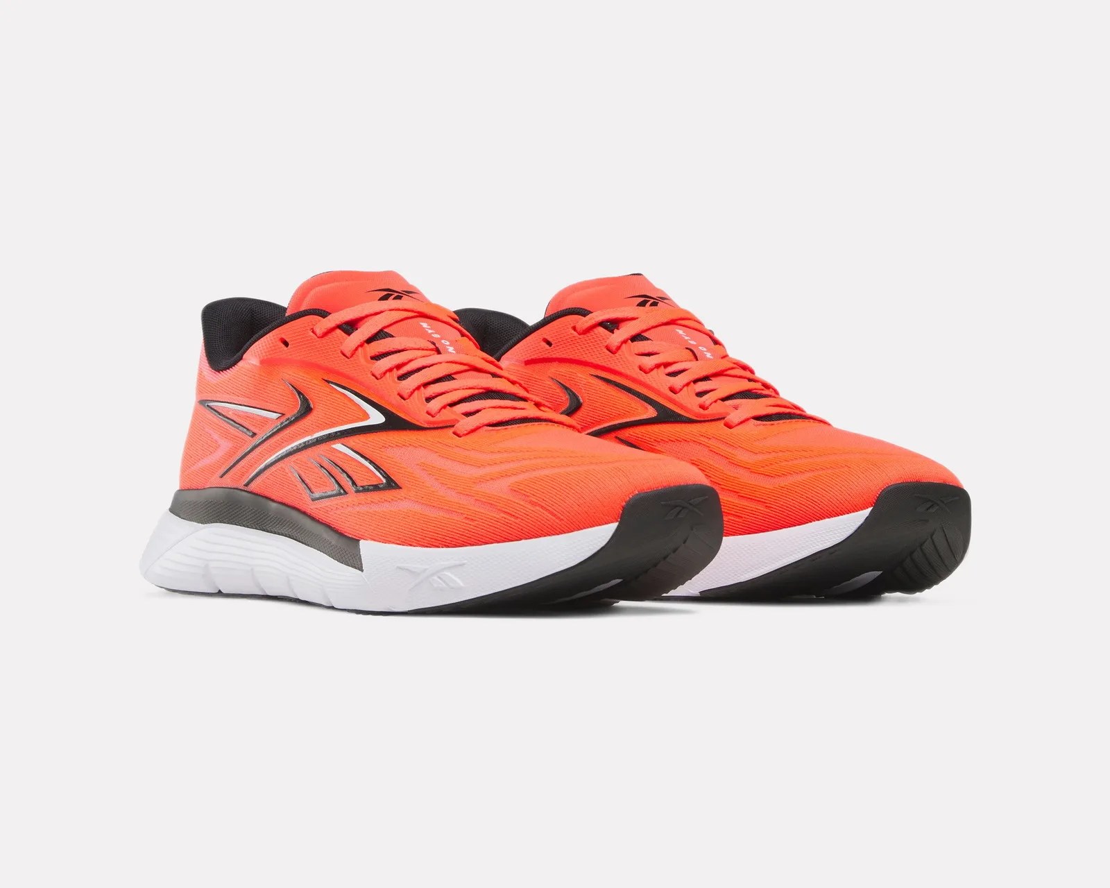 Pair of bright orange Reebok running shoes with black and white accents and white soles on a white background.