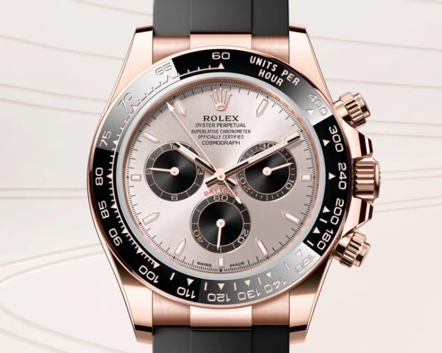 Rolex Oyster Perpetual Cosmograph Daytona watch with rose gold case, black subdials, and black rubber strap.