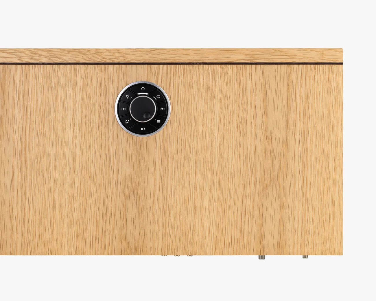 Light oak wood panel with a round black control dial featuring multiple buttons and a central knob.