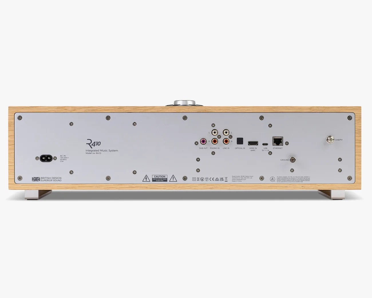 Rear panel of a wooden-cased R410 integrated music system showing various audio and network input/output ports.