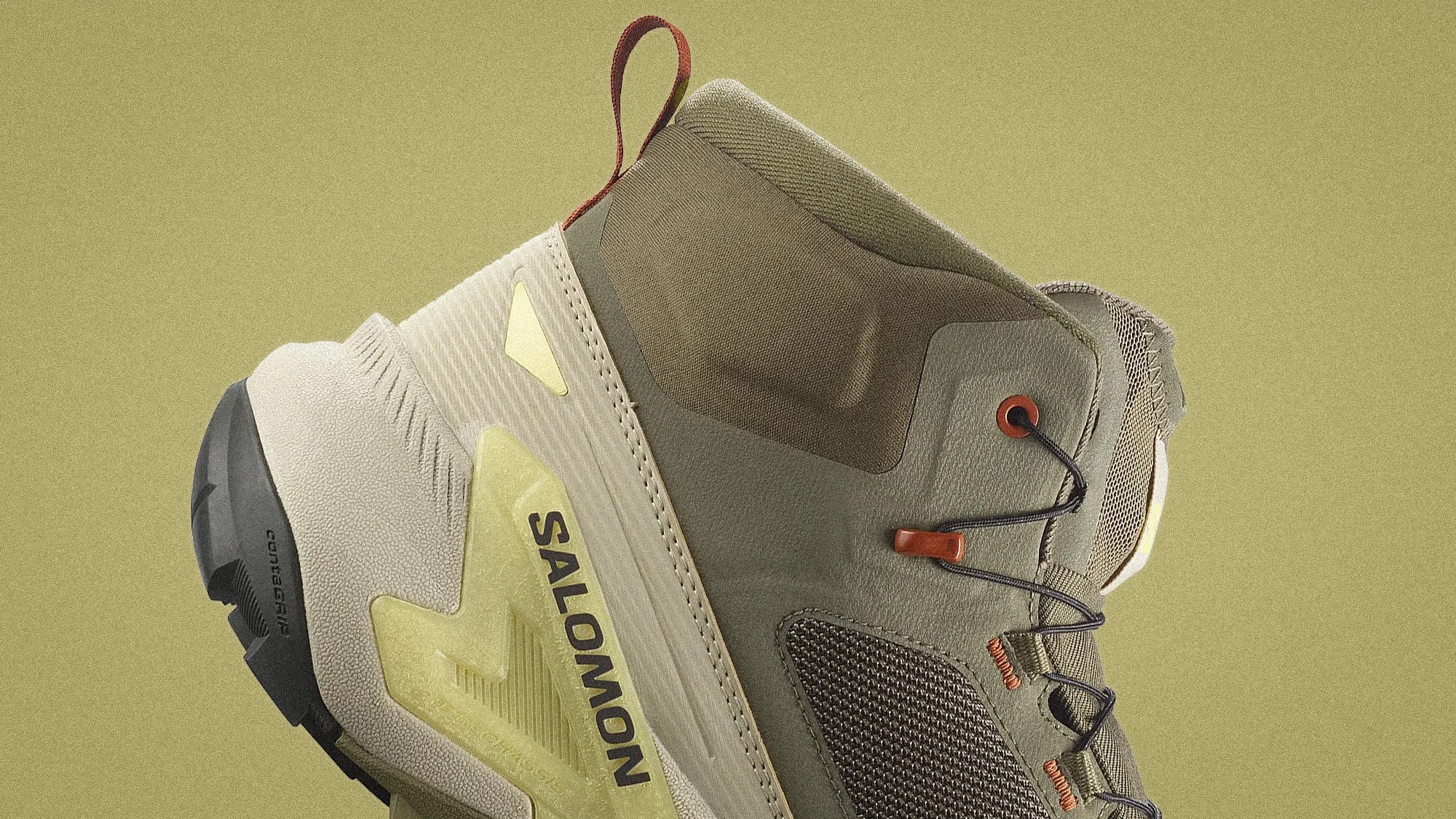 Close-up of a beige and olive green Salomon hiking shoe with black laces and a black sole.