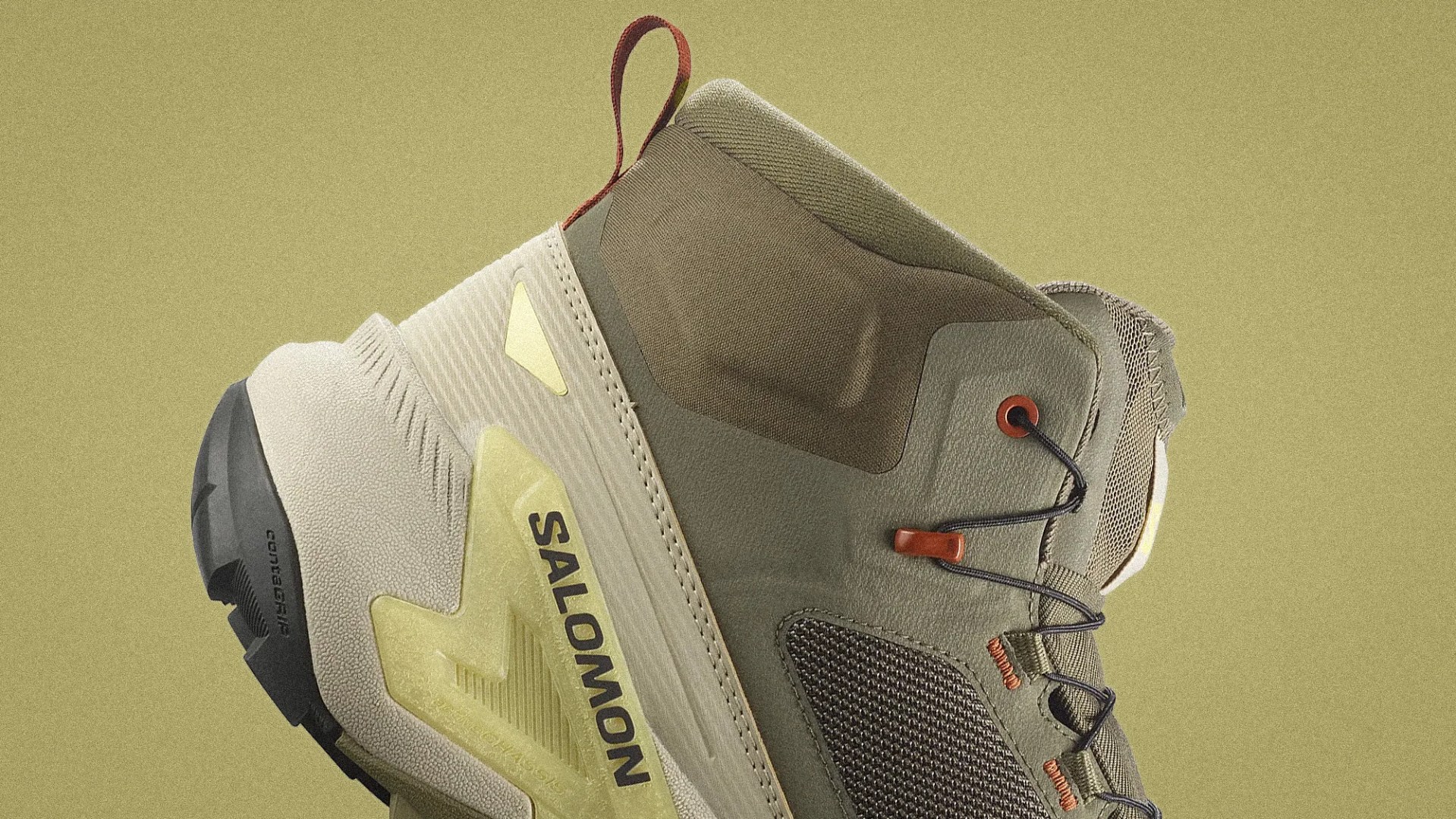 Close-up of a beige and olive green Salomon hiking shoe with black laces and a black sole.