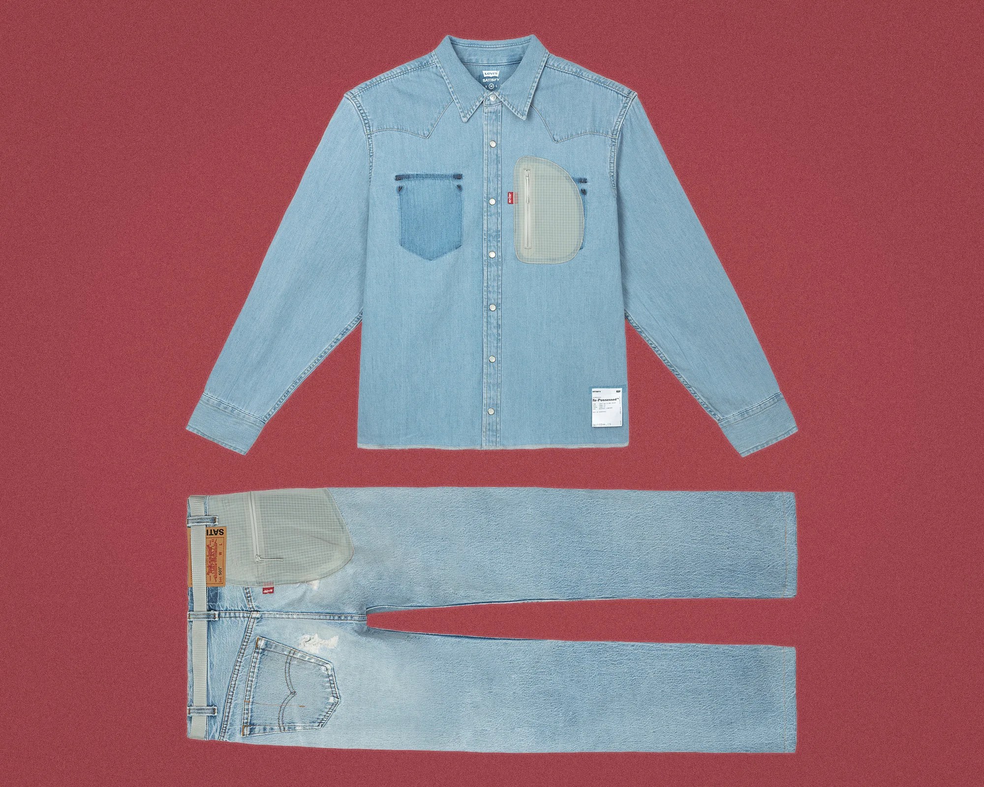 Light blue denim shirt with snap buttons and a gray zippered chest pocket paired with light blue jeans featuring a gray patch on the thigh.